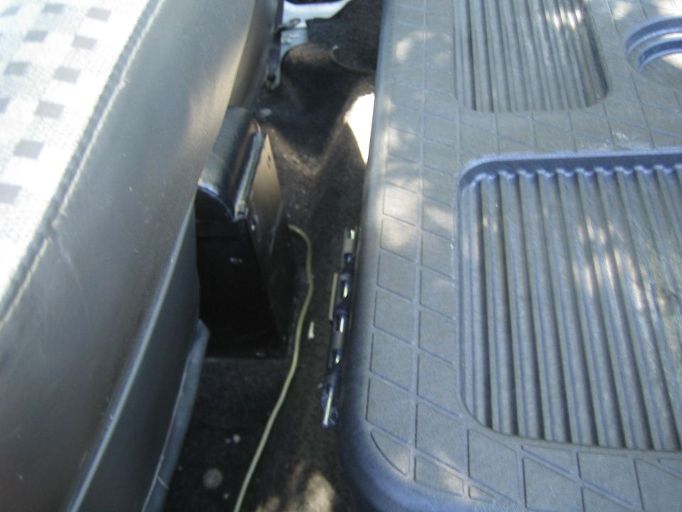 Black textured floor mat with diamond pattern and ribbed sections inside a vehicle