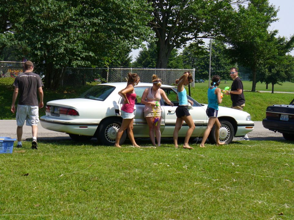White sedan parked on grass, side view