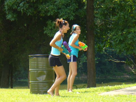 1991 Ford Probe - Two women are playing with water guns outdoors in a park-like setting.