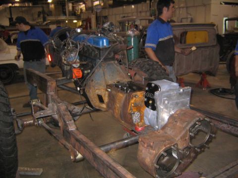 1982 Ford Bronco - A vehicle chassis is being worked on in a garage, with engine and drivetrain components visible.