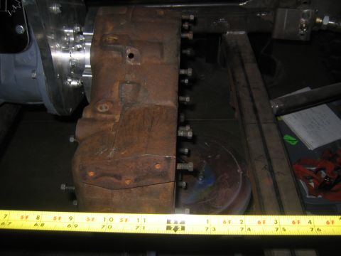 1982 Ford Bronco - A close-up view of a heavily rusted mechanical part, likely a transmission or differential housing, secured with bolts.