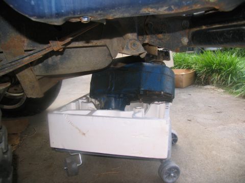 1978 Ford Bronco - A vehicle's transmission is placed on a creeper for maintenance or removal.