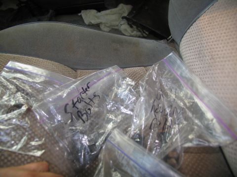 1978 Ford Bronco - Plastic bags containing bolts are placed on the interior seats of a vehicle.