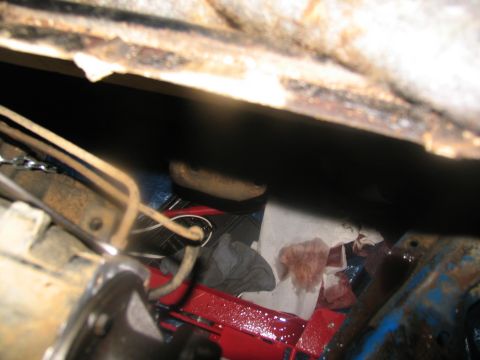 1978 Ford Bronco - A close-up view of a vehicle's undercarriage, showing mechanical parts and stained paper towels.