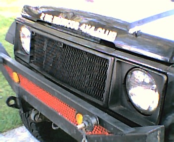 1982 Ford Customline - The front of a Suzuki Samurai is shown, a custom bumper and grille with text on the hood.