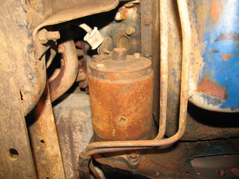 1978 Ford Bronco - Close-up of a rusty engine component, likely a fuel filter, with surrounding mechanical parts.
