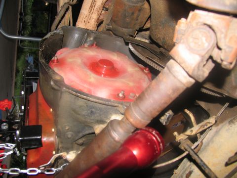 1978 Ford Bronco - Close-up view of a red torque converter and driveshaft, likely during transmission removal.