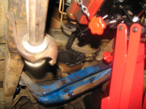1978 Ford Bronco - This photo shows the undercarriage of a vehicle, focusing on mechanical components and a red engine hoist.