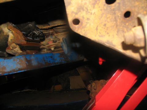 1978 Ford Bronco - Close-up view of the undercarriage, focusing on the transmission mount and rusted frame components.