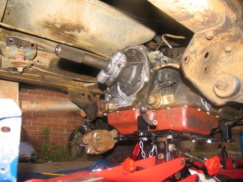 1978 Ford Bronco - Transmission and driveshaft assembly shown from below, undergoing maintenance or removal.