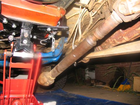 1978 Ford Bronco - Underneath view of a 1978 Ford Bronco's driveshaft and transmission support system during removal.