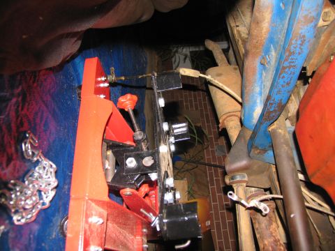 1978 Ford Bronco - Undercarriage view of a vehicle with a transmission jack attached, showing the exhaust system.