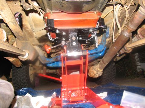 1978 Ford Bronco - Transmission jack is positioned to support the vehicle's drivetrain during removal or installation.