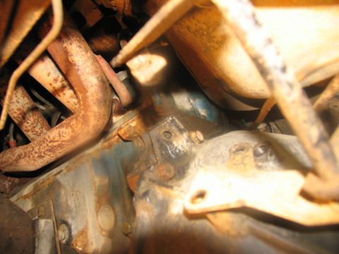 1978 Ford Bronco - Close-up view of rusty engine and exhaust components, showing signs of wear and tear.