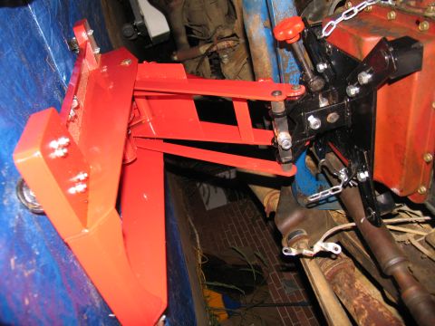 1978 Ford Bronco - A red transmission jack is positioned beneath a vehicle, likely for removal or installation of the transmission.