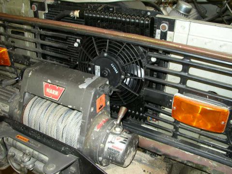 1995 Ford Bronco - Close-up of a Warn winch and electric fan assembly in front of a vehicle's grille.