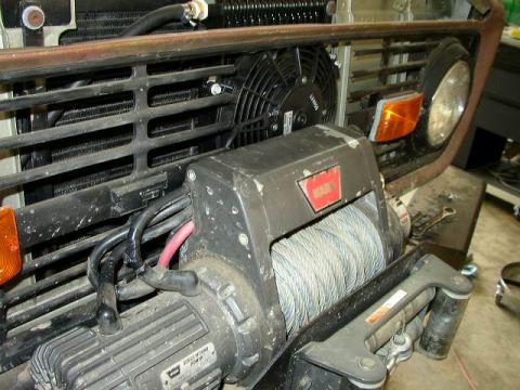 1995 Ford Bronco - Close-up of a vehicle's front end, showing a WARN winch and cooling fan assembly.