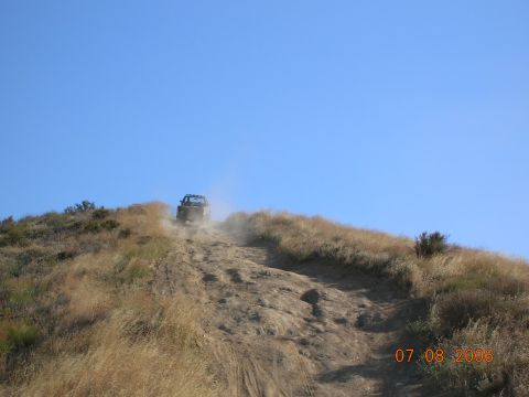 1985 Ford Bronco - Vehicle ascends a challenging, dusty trail on a sunny day.