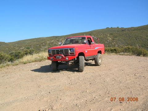 1985 Ford Bronco - This red SUV, likely from the early 1980s, is equipped for off-road use with a winch and lifted suspension.