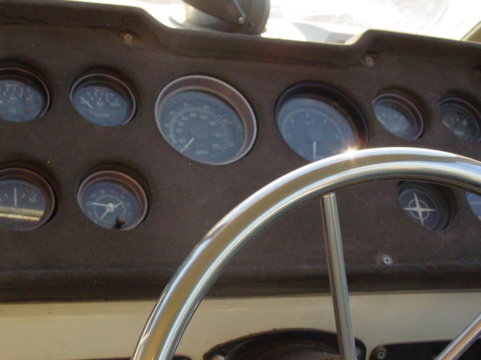 Boat helm dash with round gauges and stainless steel steering wheel