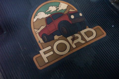 1978 Ford Bronco - A graphic depicting a 1978 Ford Bronco in a desert landscape is visible on a dark floor mat.
