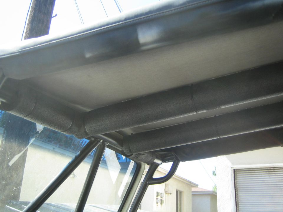Interior view of a roll cage and padded roof structure in a vehicle
