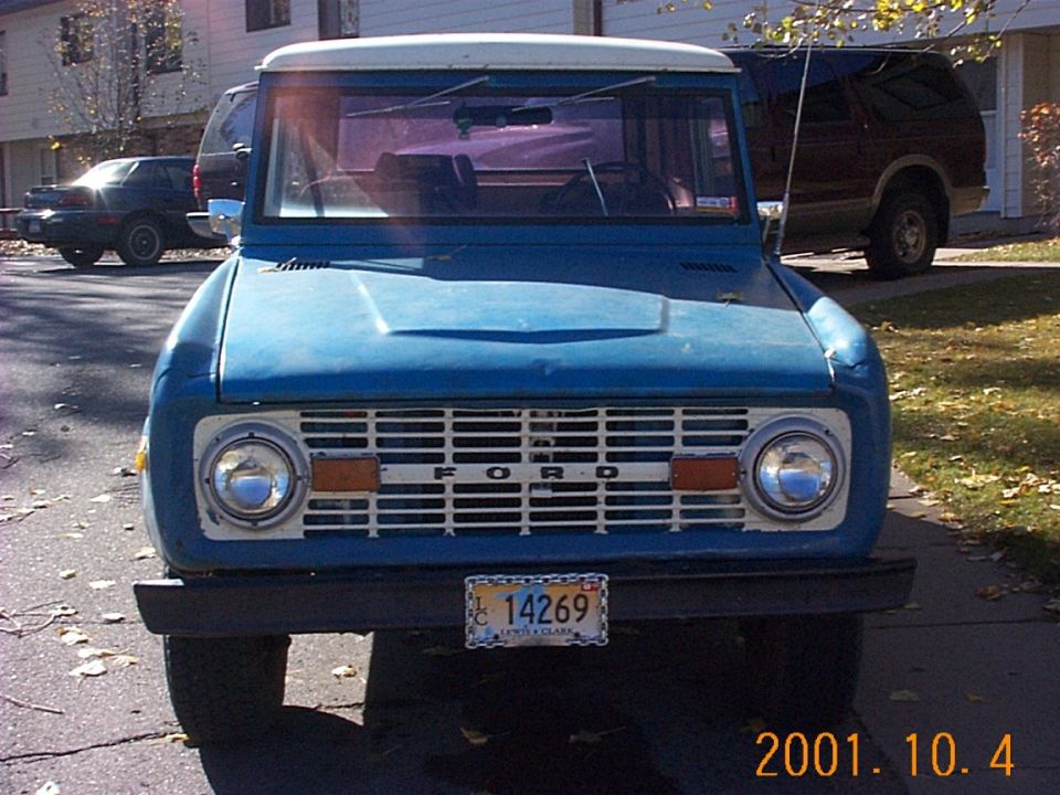 Front view of a blue early Ford Bronco with white roof and Montana plate 14269 on a residential street