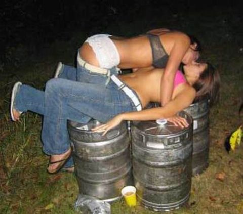 1986 Ford Bronco - Two women are embracing on top of beer kegs in a grassy area at night.