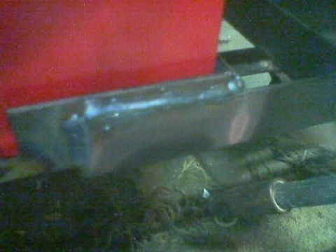 1989 Ford Bronco - Close-up view of welding work on a metal component, likely part of a vehicle's undercarriage.