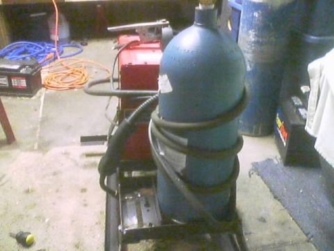 1989 Ford Bronco - Welding equipment setup, including a gas cylinder and a welding machine, in what appears to be a workshop or garage.