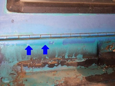 1972 Ford Bronco - This close-up shows significant rust and damage on a vehicle's body panel.