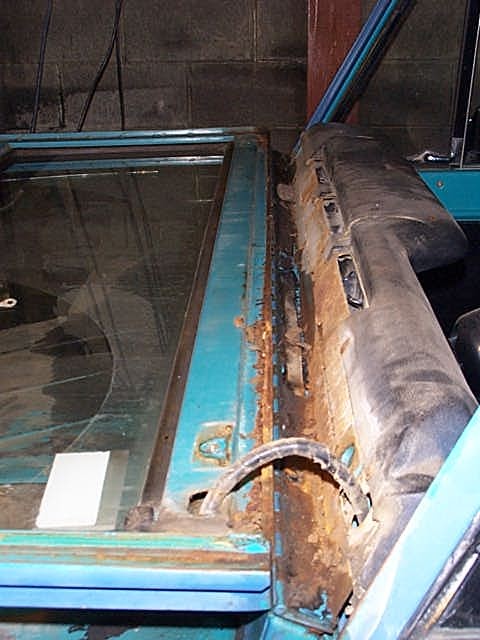1972 Ford Bronco - The interior of a 1972 Ford Bronco shows extensive rust damage around the door frame and window seal.