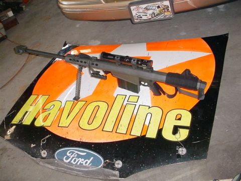 1972 Ford Ranchero - A sniper rifle rests on a Ford hood with Havoline sponsorship graphics.