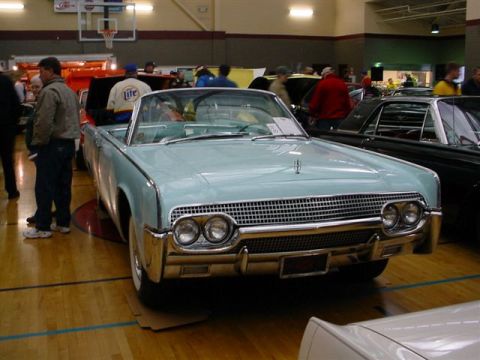 1972 Ford Ranchero - A light blue 1961 Lincoln Continental convertible is displayed indoors with other vehicles.