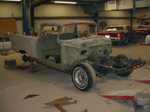 1972 Ford Ranchero - A disassembled pickup truck body sits in a workshop, awaiting restoration, with other vehicles visible in the background.