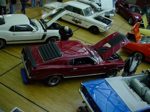 1972 Ford Ranchero - A red coupe, possibly a 1970 model, is displayed with its hood open at a car show.