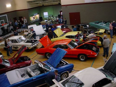 1972 Ford Ranchero - A variety of classic cars are on display at an indoor car show event.