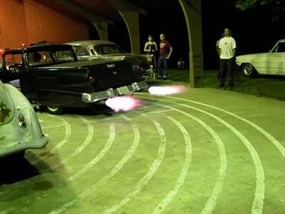 1972 Ford Ranchero - A classic station wagon emits flames from its exhaust pipes at night, with onlookers present.