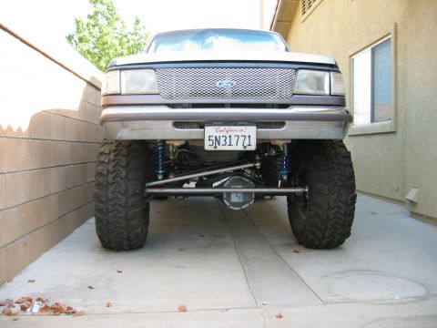 1997 Ford Ranger - This lifted Ford truck features oversized tires and a custom suspension system, viewed from the front.