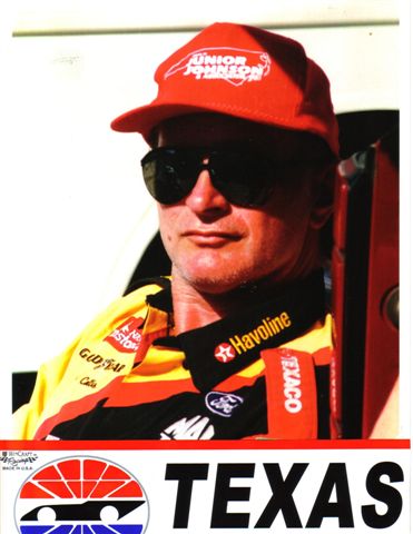 1972 Ford Ranchero - A close-up portrait of a man wearing a red cap and sunglasses, with various sponsor logos visible on his racing attire.