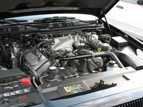 2003 Ford Crown Victoria - The engine bay of a 2003 Ford Crown Victoria shows its V8 engine and various components.
