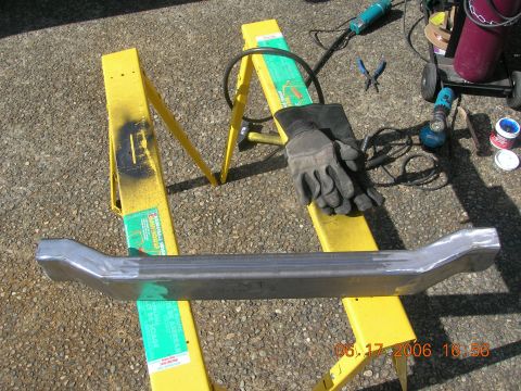1996 Ford Bronco - A metal bumper part rests on yellow sawhorses, surrounded by welding tools and gloves.