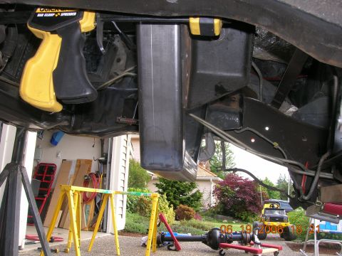 1996 Ford Bronco - A yellow Ford Bronco is visible in the background while the underbody of another vehicle is being worked on.