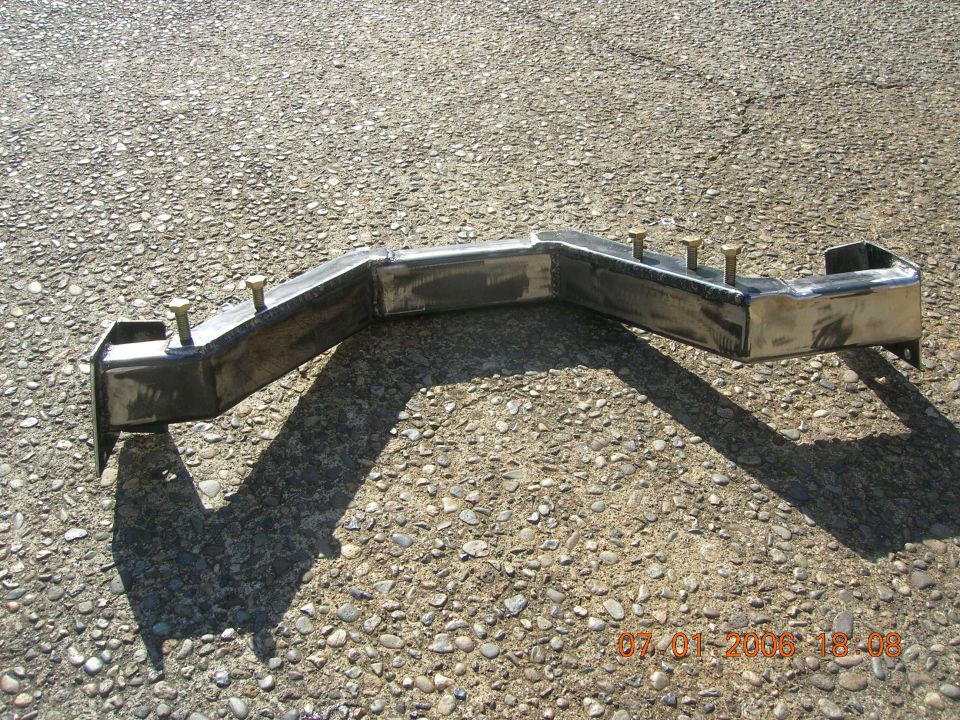 Bare welded steel crossmember with studs and end brackets on pavement