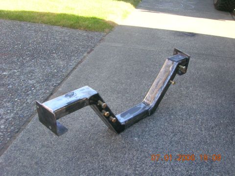 1996 Ford Bronco - A custom-fabricated metal bracket with multiple bolt holes is shown resting on a concrete surface.