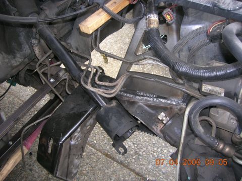 1996 Ford Bronco - Welded repairs visible on vehicle frame near engine components and wiring harness.