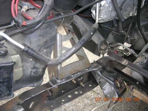 1996 Ford Bronco - This photo shows the engine bay and frame of a vehicle, with visible welding and various hoses and wires.