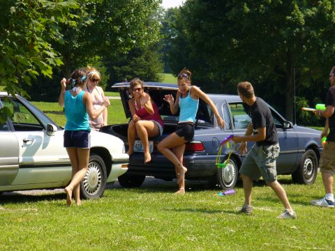 1991 Ford Probe - A group of friends enjoy a sunny day outdoors with two cars present and water guns.