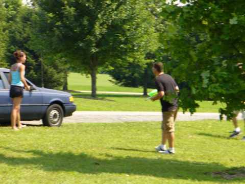 1991 Ford Probe - A blue sedan is parked on a grassy area with a woman standing next to it.