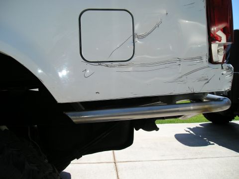 1993 Ford Bronco - Rear view of a white 1993 Ford Bronco showing the fuel door and a damaged rear bumper.